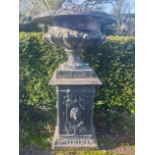 A large cast iron urn on pedestal