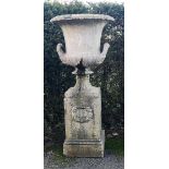 A compostion stone urn on pedestal