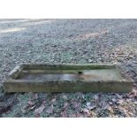 A shallow rectangular carved stone trough