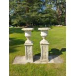 A pair of composition stone urns