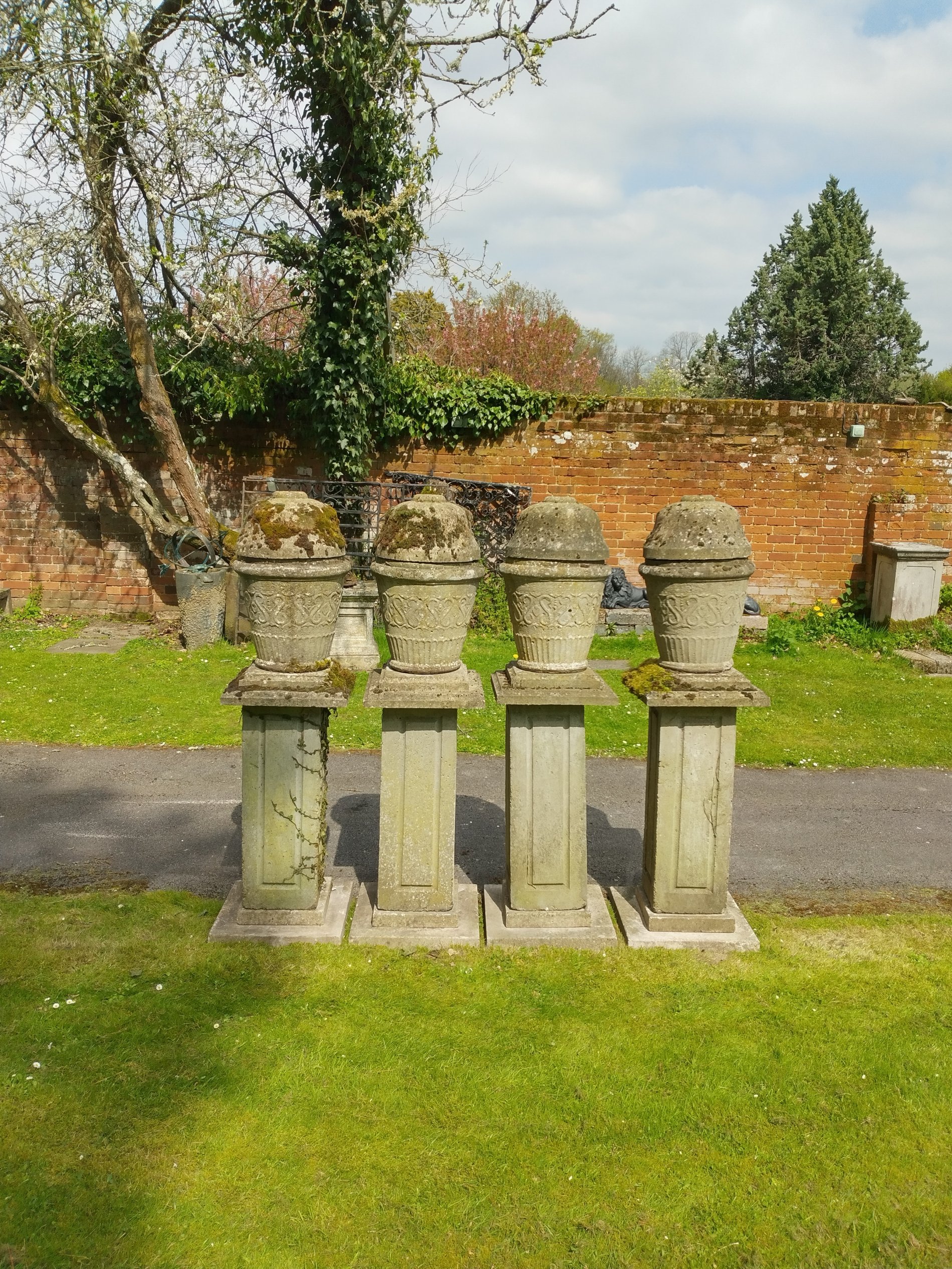 A set of four composition stone finials on plinths