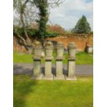 A set of four composition stone finials on plinths