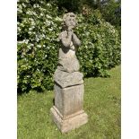 A carved figure on composition stone base