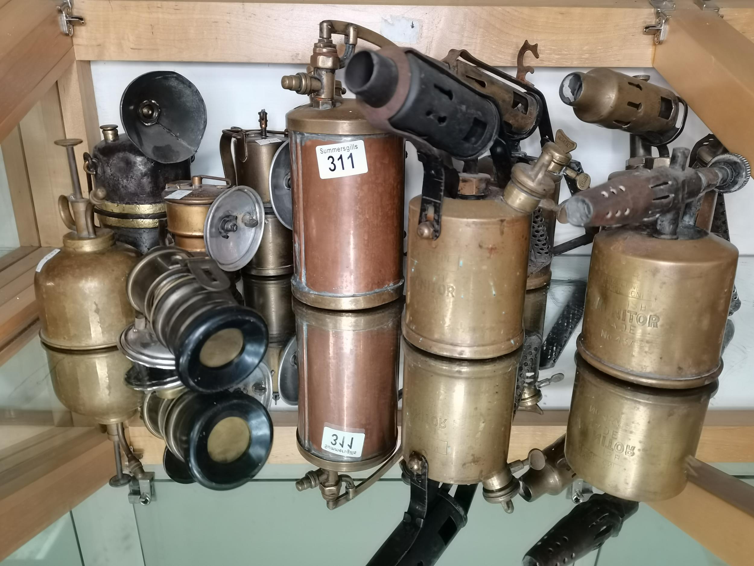 A collection of antique blow torches and carbine lamps