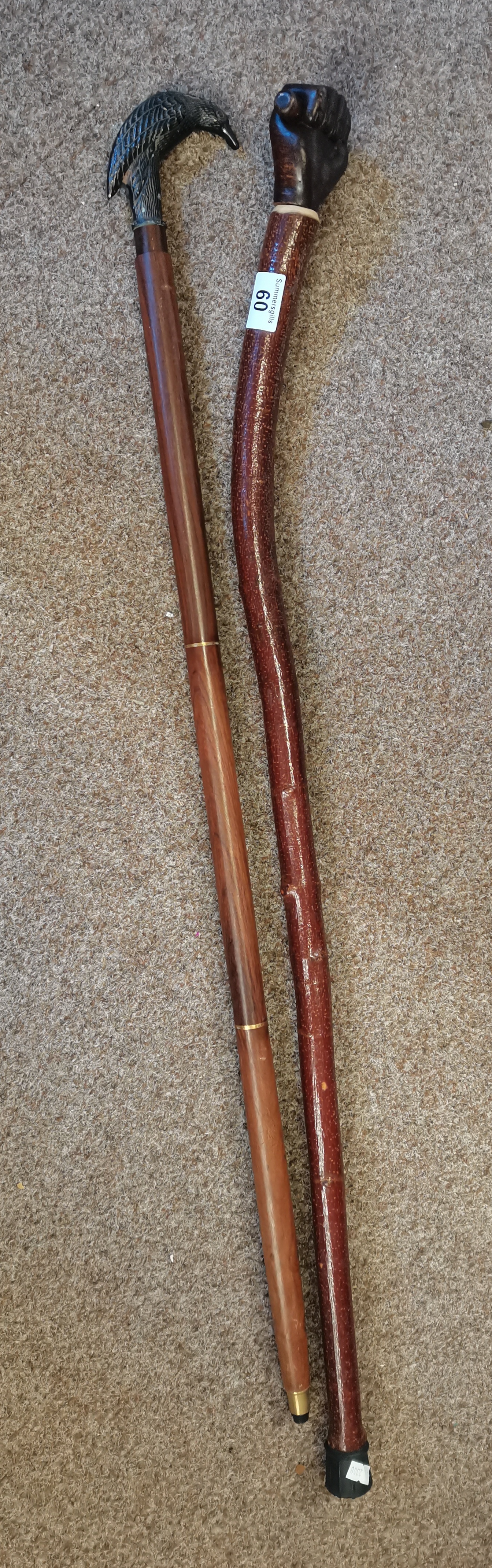 x2 Walking sticks one with a bird head and other with a clenched fist