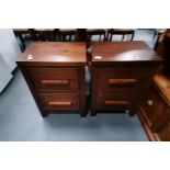 A pair of dark wood bedside drawers