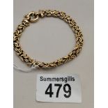 A 14k gold bracelet highly decorative with loop fa