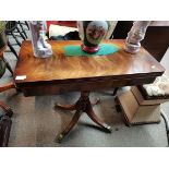 A lovely Mahogany fold over card table with brass claw feet on castors