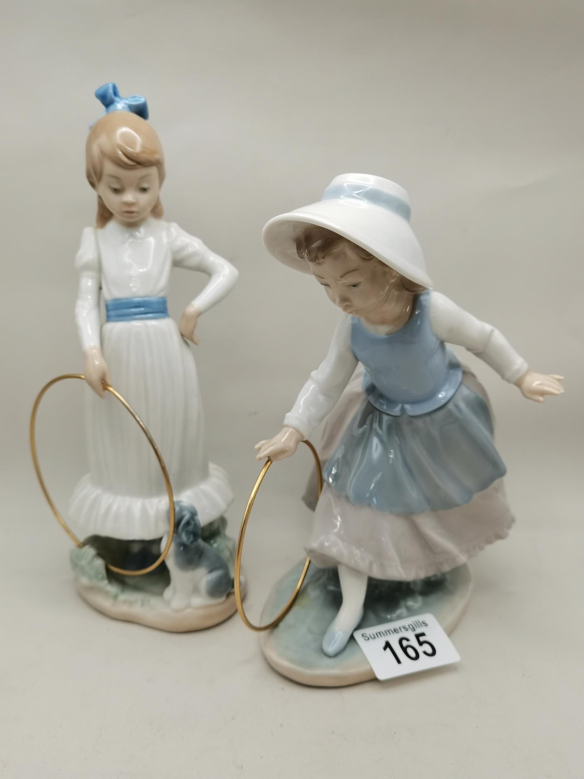 A pair of Nao figurines - Girl training her dog and Girl pushing a hoop