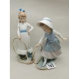A pair of Nao figurines - Girl training her dog and Girl pushing a hoop