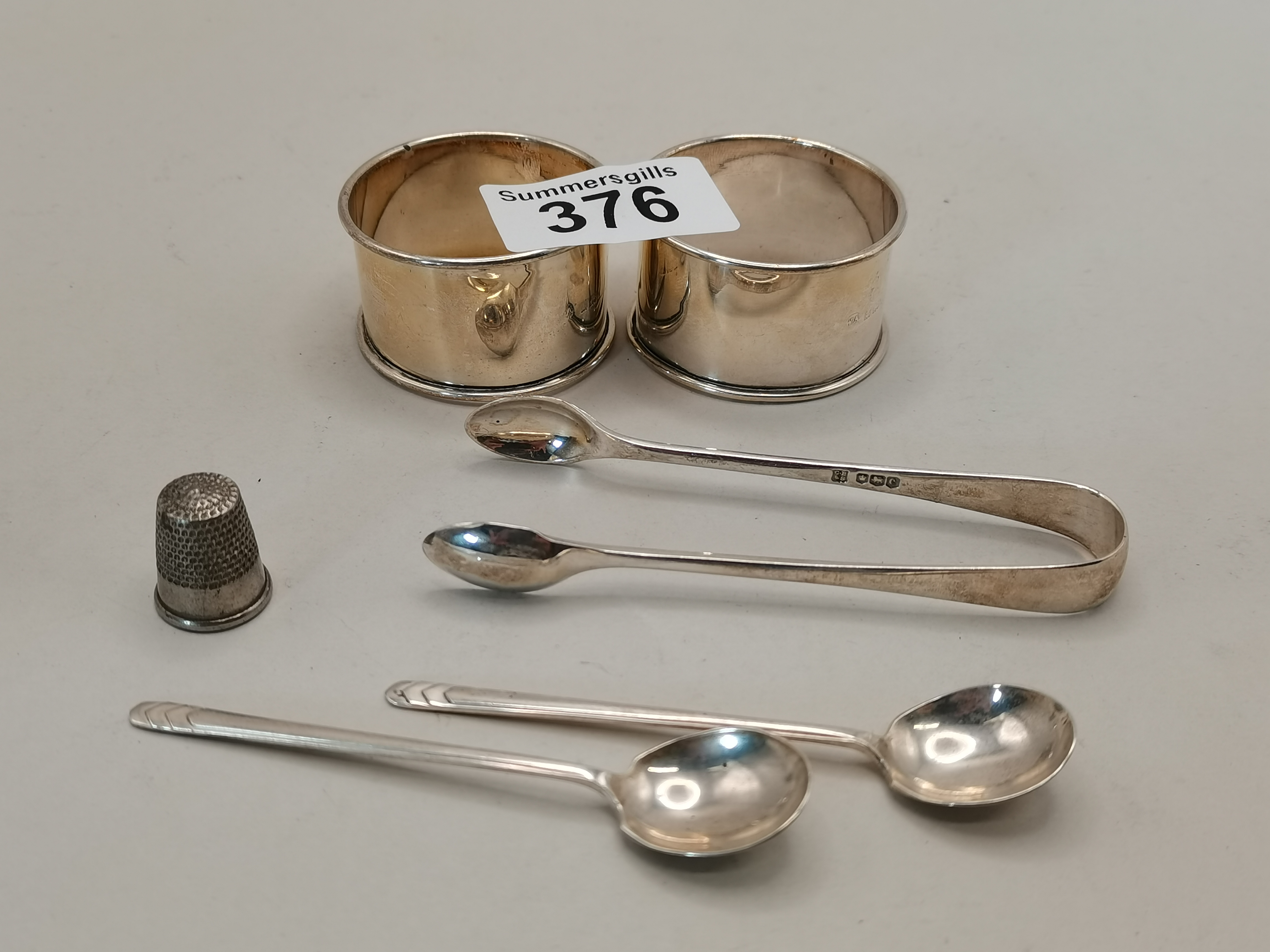 Silver items including napkin rings, sugar tongs and spoons