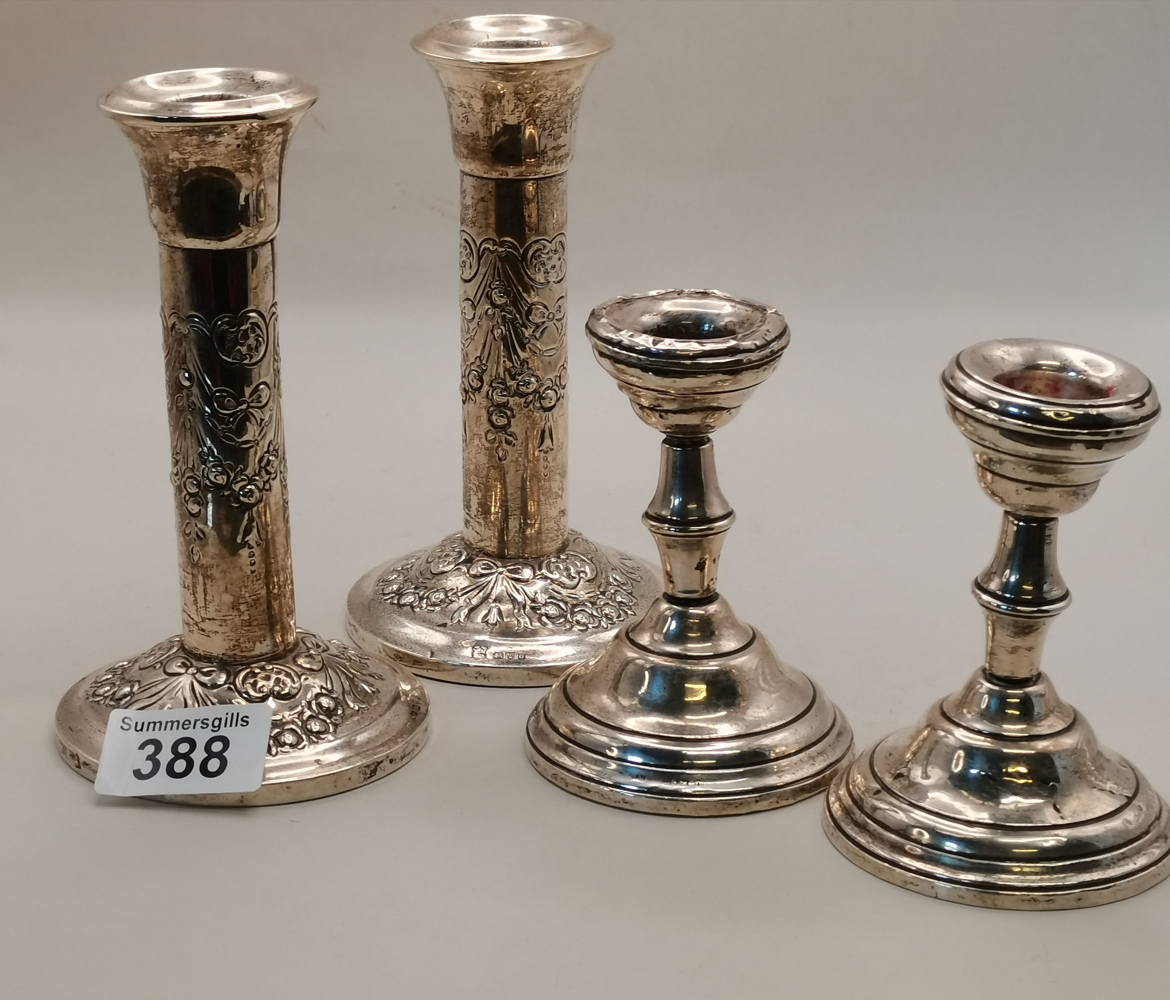 A pair of Chester silver candlesticks and another