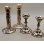 A pair of Chester silver candlesticks and another