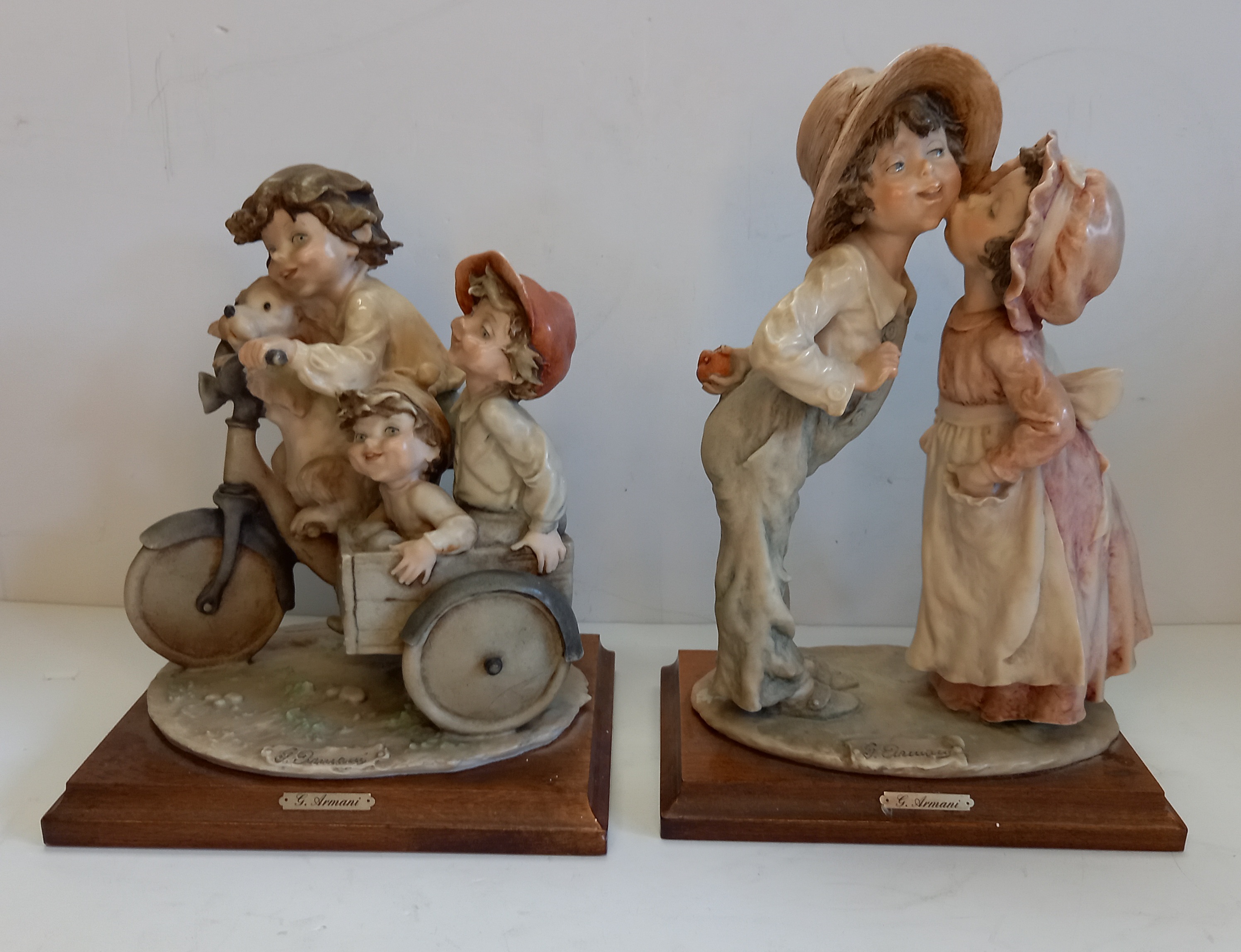 2 x Guiseppe Armani Figurines - Italian Porcelain 'Shy Kiss' 1982 and Children on a bike with dog