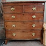 A Georgian mahogany bow fronted 4 height chest with sabre legs and brass handles