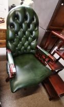 A green leather button backed office chair