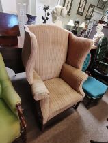 An Edwardian wing back chair with mahogany fluted