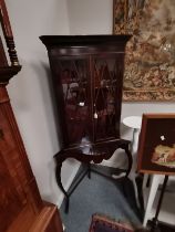 An antique mahogany corner standing cupboard