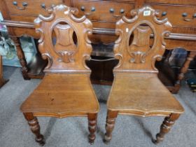 A pair of Victorian oak hall chairs