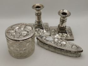 A pair of Edwardian silver candlesticks, and two silver-mounted dressing table jars