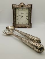 An Elizabeth II silver-mounted Harrods mantel clock, and a pair of salad servers