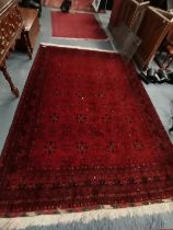 A 3m x 2m mostly red and blue rug with highly decorate