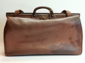 A brown leather Gladstone travel bag