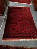 A 2.1m x 1.5m mostly red and blue rug