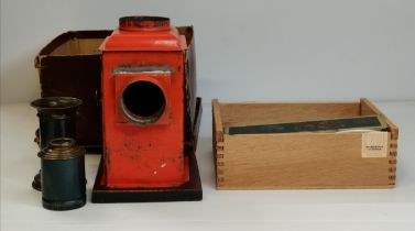 A metal magic lantern and box of coloured slides