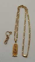 A 9ct gold chain with hieroglyphics yellow metal pendant