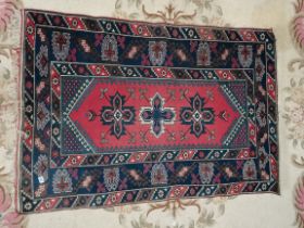A small red and blue Turkish rug 1.7m x 1.2m
