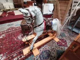 A beautifully painted rocking horse on pine stand