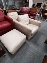 A pair of cream leather arm chairs and matching st