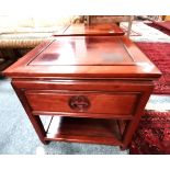 A pair of Chinese mahogany bedside cabinets