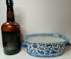 A blue and white ceramic twin-handled foot bath planter, and a large Bols advertising bottle