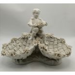 A Meissen creamware style figure of a boy with flo