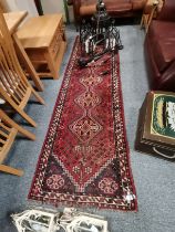 A 2.9m x 85cm runner in mostly red colours with di