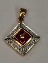 A 9ct gold pendant with diamond and ruby stones