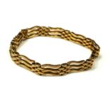 AN EARLY 20TH CENTURY 15CT GOLD GATE BRACELET Having three bars of pierced wave form links. (