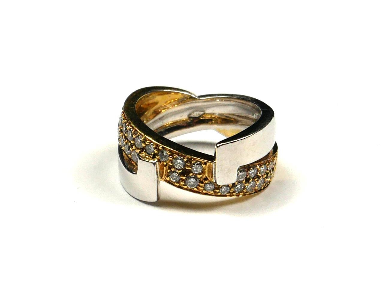 AN 18CT BICOLOUR GOLD AND DIAMOND HALF TWIST RING Two rows of round cut diamonds on a yellow gold
