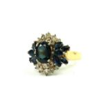 A VINTAGE 14CT GOLD, DIAMOND AND SAPPHIRE CLUSTER RING The oval cut central sapphire edged with
