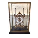A LARGE BRASS SKELETON MANTEL CLOCK Having four glazed panels, a white circular dial and two