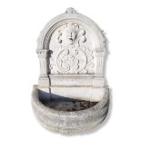 AN 18TH CENTURY STYLE STONE GARDEN FOUNTAIN The arched top with facial mask above foliage, flanked