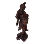 A 19TH CENTURY CHINESE HARDWOOD CARVING OF A FARMER Wearing a long robe and holding a water