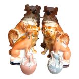 A PAIR OF EDWARDIAN STAFFORDSHIRE SEATED DOGS With gold collars and glass eyes, along with a pair of