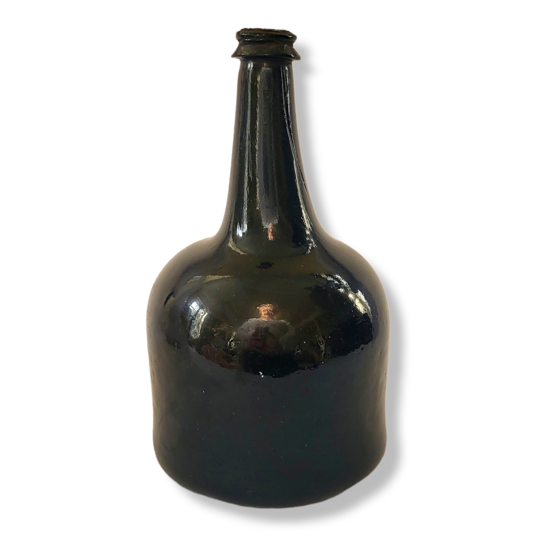 AN EARLY 18TH CENTURY MALLET FORM DARK GLAZED GLASS PORT BOTTLE, CIRCA 1700 - 1725 Having original