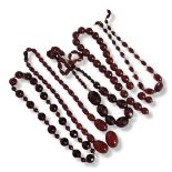 A COLLECTION OF VICTORIAN CHERRY AMBER BEADS To include faceted and plain amber beads. (largest bead