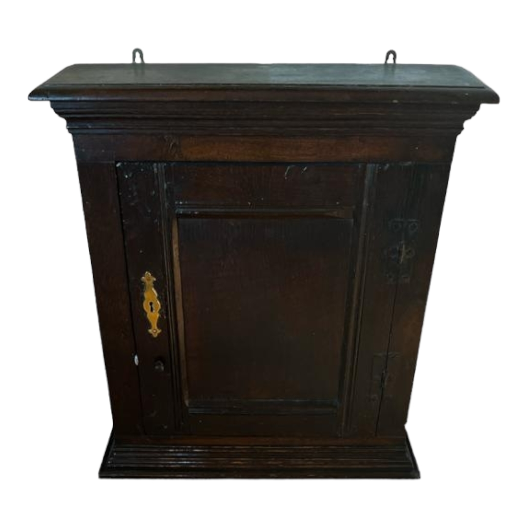 WITHDRAWN!! AN 18TH CENTURY OAK WALL HANGING CUPBOARD The single door with brass escutcheon