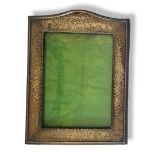 AN EARLY 20TH CENTURY SILVER PHOTOGRAPH FRAME Having an arched top, hammered finish and leather clad