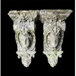 A PAIR OF CAST STONE CORBELS Figured with facial masks and foliage. (length 46cm) Condition:
